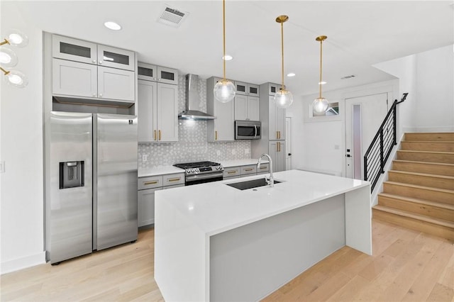 3321 Hemlock Ave Unit 2, Austin, TX 78722 - kitchen with appliances with stainless steel finishes, wall chimney range hood, light wood-style floors, decorative backsplash, and recessed lighting