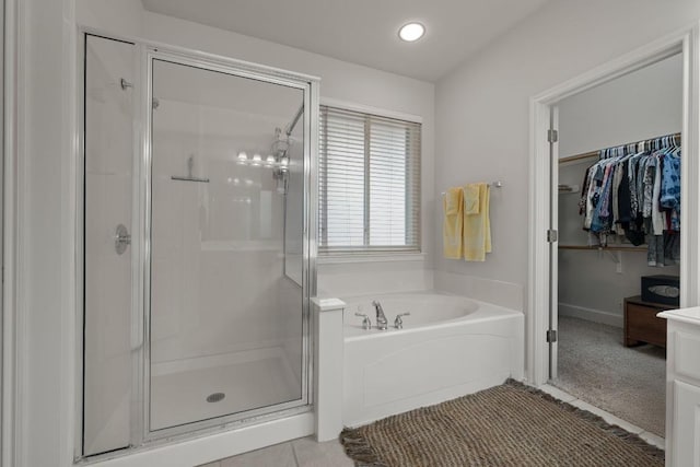 13129 Halsell Dr, Austin, TX 78732 - bathroom with a stall shower, a garden tub, a spacious closet, tile patterned floors, and recessed lighting