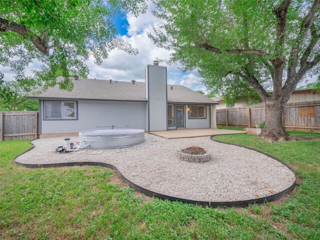 8100 Beaconcrest Dr, Austin, TX 78748 - back of property with a patio area, a fire pit, a chimney, and a fenced backyard