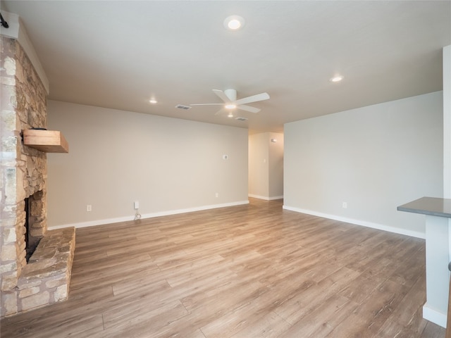 8100 Beaconcrest Dr, Austin, TX 78748 - unfurnished living room with ceiling fan, light wood-style floors, recessed lighting, and a stone fireplace