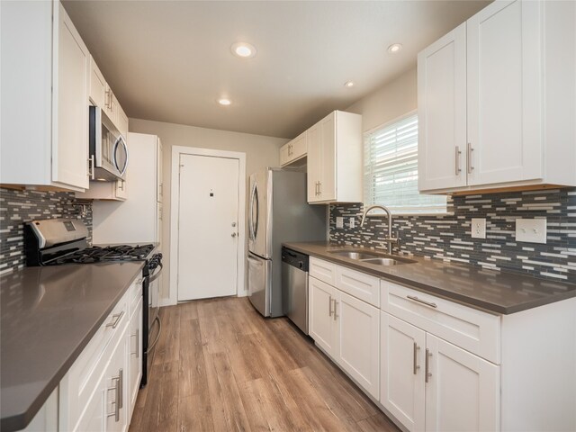 8100 Beaconcrest Dr, Austin, TX 78748 - kitchen with appliances with stainless steel finishes, dark countertops, light wood finished floors, white cabinets, and recessed lighting