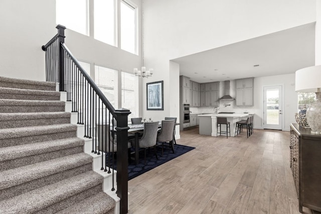 904 Arundel Rd, Lakeway, TX 78738 - dining area with stairs, light wood-type flooring, a towering ceiling, and a chandelier