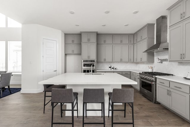 904 Arundel Rd, Lakeway, TX 78738 - kitchen featuring gray cabinets, wall chimney exhaust hood, high end stove, backsplash, and recessed lighting