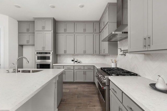 904 Arundel Rd, Lakeway, TX 78738 - kitchen with gray cabinets, appliances with stainless steel finishes, wall chimney exhaust hood, and a sink