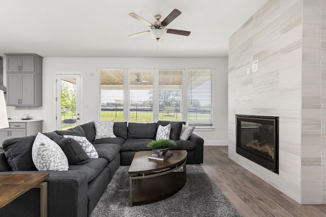 904 Arundel Rd, Lakeway, TX 78738 - living room featuring a ceiling fan, wood finished floors, a glass covered fireplace, and baseboards