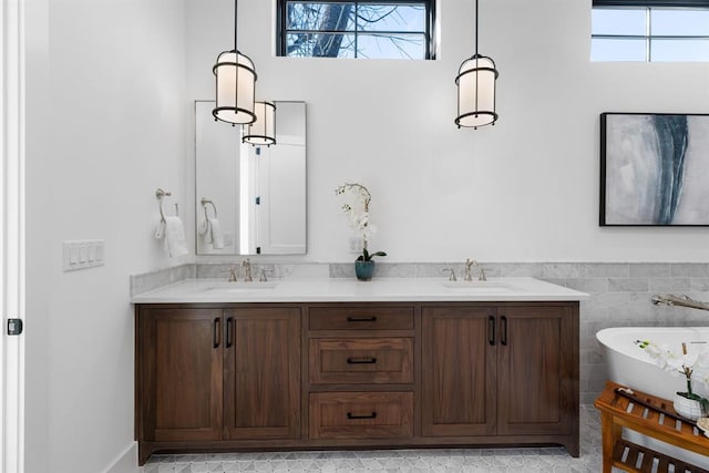 1207 Aggie Ln, Austin, TX 78757 - bathroom featuring a freestanding bath, plenty of natural light, double vanity, and a wainscoted wall