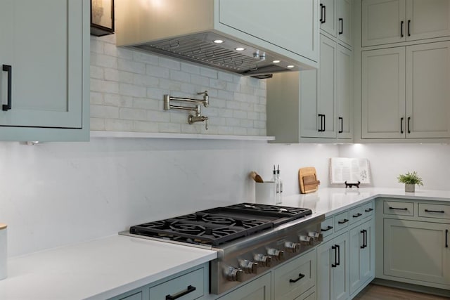 1207 Aggie Ln, Austin, TX 78757 - kitchen with stainless steel gas stovetop, light countertops, decorative backsplash, and exhaust hood