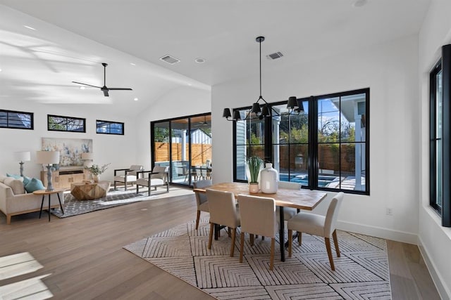 1207 Aggie Ln, Austin, TX 78757 - dining room featuring wood finished floors, lofted ceiling, a chandelier, ceiling fan, and recessed lighting