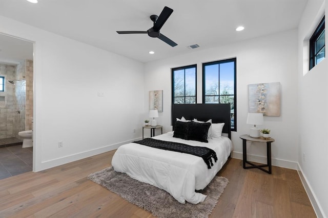 1207 Aggie Ln, Austin, TX 78757 - bedroom with multiple windows, recessed lighting, wood finished floors, and connected bathroom