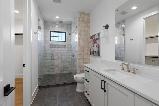 1207 Aggie Ln, Austin, TX 78757 - bathroom with a shower stall, a walk in closet, vanity, tile patterned floors, and recessed lighting