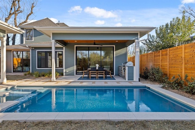 1207 Aggie Ln, Austin, TX 78757 - back of property featuring a fenced backyard, a patio area, ceiling fan, a pool with connected hot tub, and a shingled roof