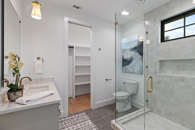 6505 Nasco, Austin, TX 78757 - full bathroom with a stall shower, double vanity, tile patterned flooring, toilet, and a walk in closet