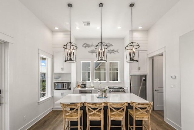 214 Sunset Ave Unit 5, Port Aransas, TX 78373 - kitchen with stainless steel appliances, dark wood-style floors, white cabinetry, light countertops, and a kitchen island