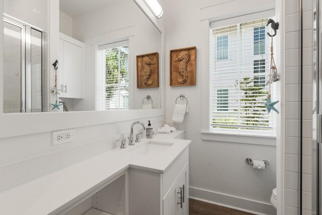 214 Sunset Ave Unit 5, Port Aransas, TX 78373 - bathroom with a shower stall, vanity, toilet, baseboards, and wood finished floors