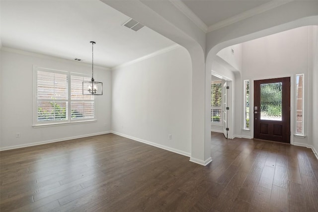 14408 Broadwinged Hawk Dr, Austin, TX 78738 - entrance foyer featuring a chandelier, dark wood-type flooring, baseboards, crown molding, and arched walkways