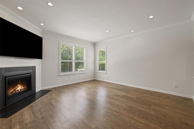 14408 Broadwinged Hawk Dr, Austin, TX 78738 - unfurnished living room featuring ornamental molding, a warm lit fireplace, wood finished floors, baseboards, and recessed lighting