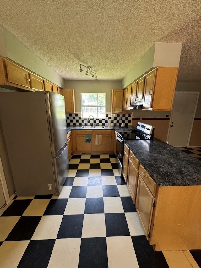 405 Lynch St, Smithville, TX 78957 - kitchen featuring stainless steel appliances, tile patterned floors, decorative backsplash, and under cabinet range hood