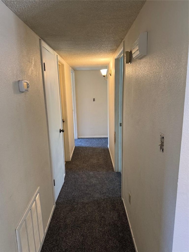 405 Lynch St, Smithville, TX 78957 - corridor featuring a textured ceiling and dark carpet