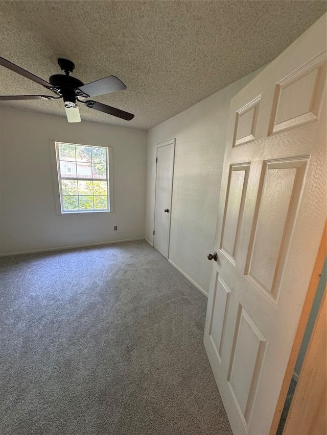 405 Lynch St, Smithville, TX 78957 - unfurnished bedroom featuring carpet flooring, ceiling fan, and a textured ceiling