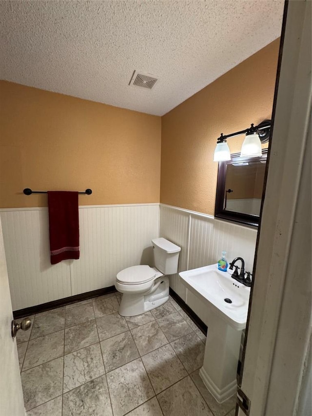 405 Lynch St, Smithville, TX 78957 - bathroom with a wainscoted wall and a textured ceiling