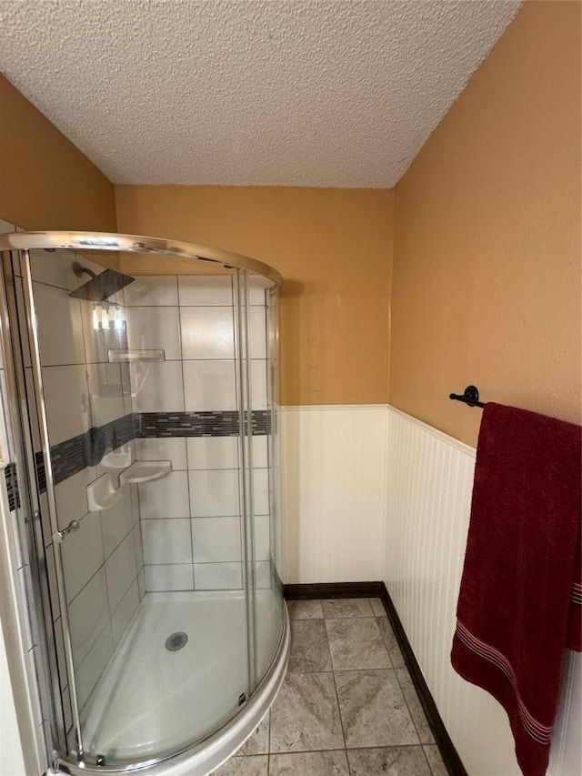 405 Lynch St, Smithville, TX 78957 - bathroom featuring wainscoting, a stall shower, and a textured ceiling