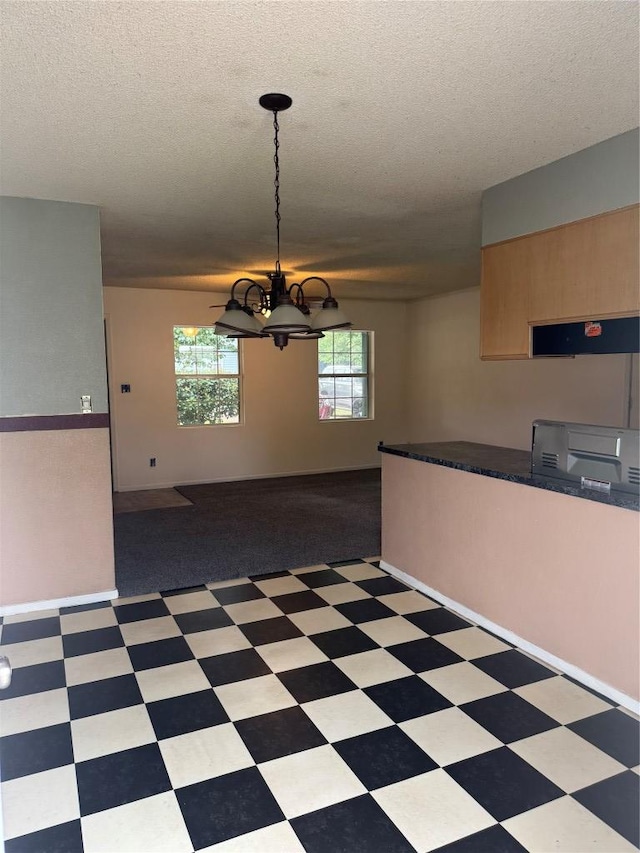 405 Lynch St, Smithville, TX 78957 - unfurnished dining area with a chandelier, a textured ceiling, and tile patterned floors