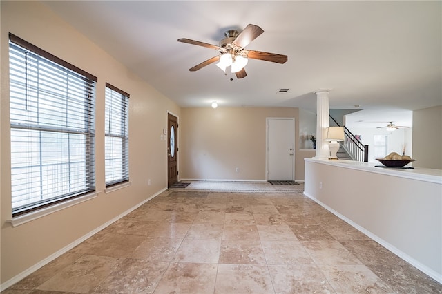 11228 Pickard Ln, Austin, TX 78748 - empty room with a ceiling fan, ornate columns, baseboards, light stone finish flooring, and stairway