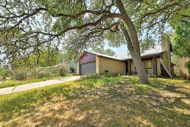 507 W Dittmar Rd, Austin, TX 78745 - view of front facade with an attached garage, metal roof, driveway, a chimney, and brick siding
