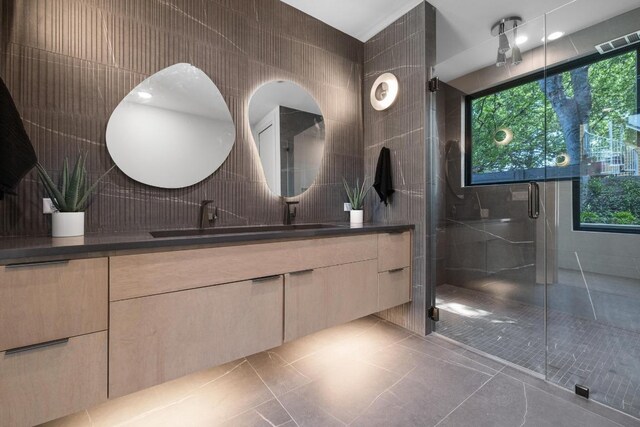 2106 Thornton Rd, Austin, TX 78704 - full bath with double vanity, tile walls, tile patterned floors, a shower stall, and plenty of natural light
