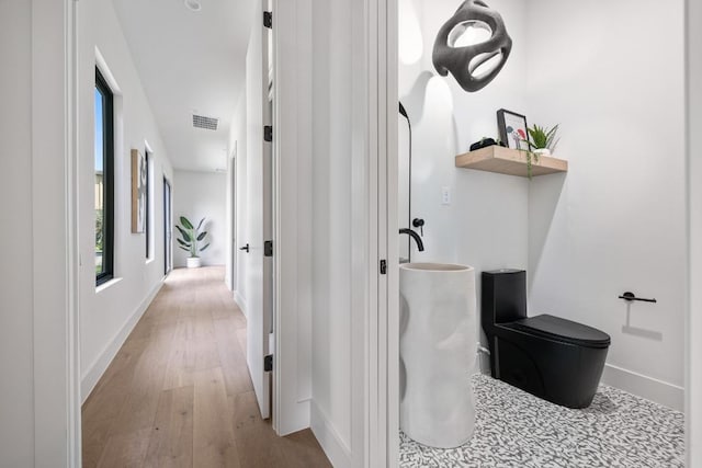 2106 Thornton Rd, Austin, TX 78704 - bathroom featuring wood finished floors, baseboards, and toilet