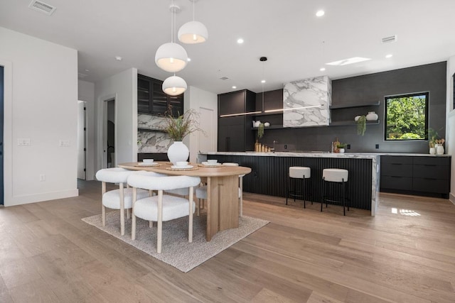 2106 Thornton Rd, Austin, TX 78704 - dining space with light wood finished floors, bar with sink, and recessed lighting