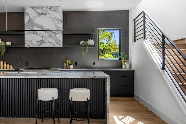 2106 Thornton Rd, Austin, TX 78704 - bar area with baseboards, stairway, light wood finished floors, and backsplash