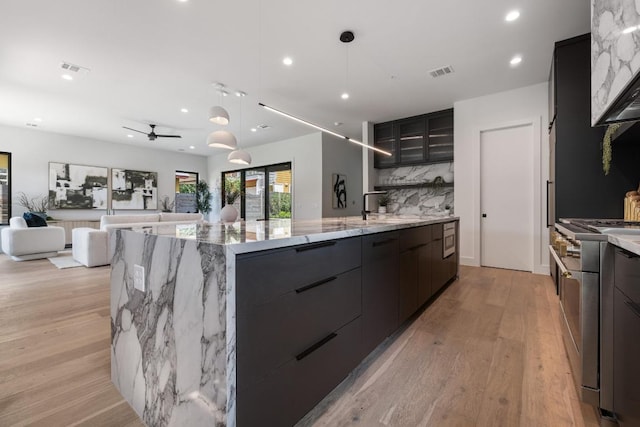 2106 Thornton Rd, Austin, TX 78704 - kitchen with modern cabinets, range with two ovens, light wood-style flooring, a sink, and recessed lighting