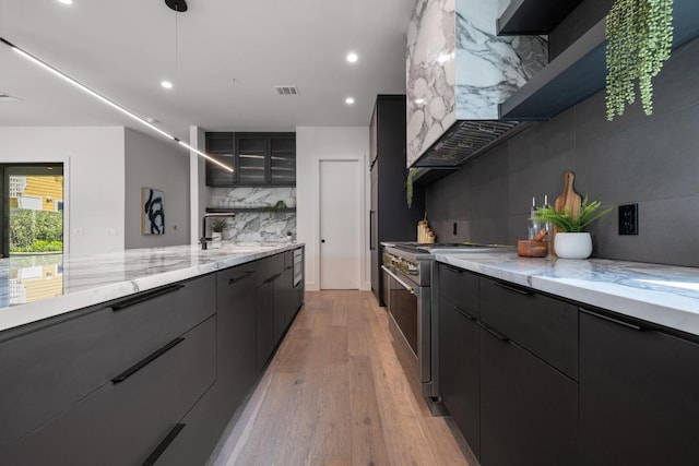 2106 Thornton Rd, Austin, TX 78704 - kitchen with stainless steel appliances, decorative backsplash, a sink, light wood-style floors, and modern cabinets