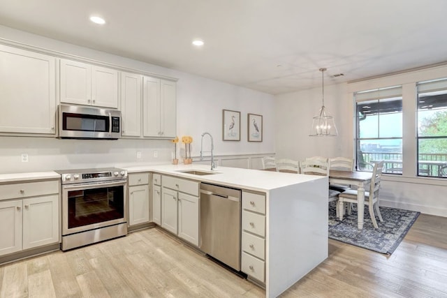 6712 Lantern View Dr Unit 303, Jonestown, TX 78645 - kitchen with stainless steel appliances, a peninsula, light wood finished floors, light countertops, and recessed lighting