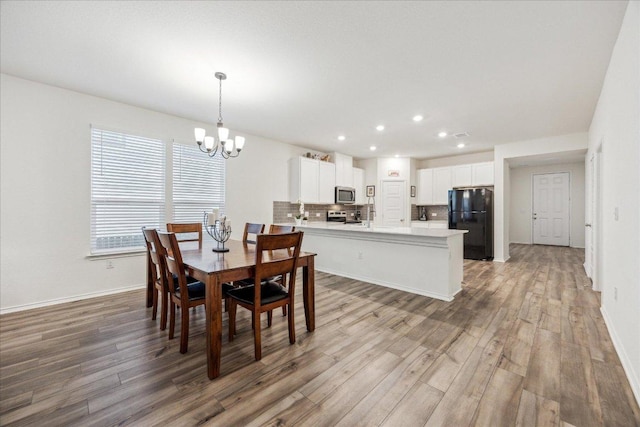 7008 Daniel Ranch Dr, Austin, TX 78744 - dining area with a chandelier, light wood-type flooring, recessed lighting, and baseboards