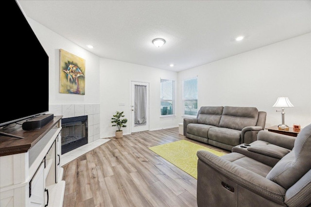 7008 Daniel Ranch Dr, Austin, TX 78744 - living room featuring light wood finished floors, a tile fireplace, and recessed lighting