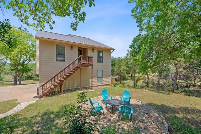 156 Lakefront Dr, Point Venture, TX 78645 - back of property featuring stairs, metal roof, a yard, and a standing seam roof