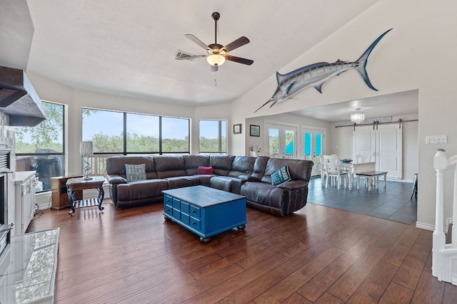 156 Lakefront Dr, Point Venture, TX 78645 - living area featuring a barn door, dark wood-style floors, a ceiling fan, plenty of natural light, and high vaulted ceiling