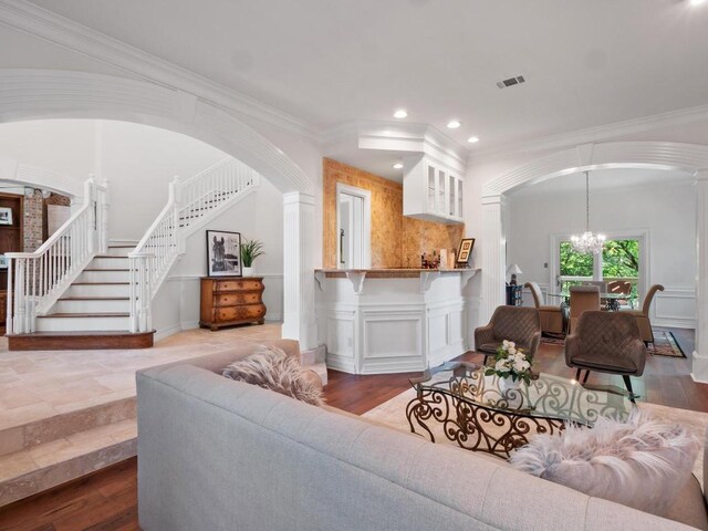 1300 Puddleby Cv, Austin, TX 78746 - living area with arched walkways, stairway, a chandelier, crown molding, and recessed lighting
