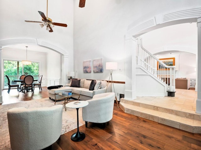 1300 Puddleby Cv, Austin, TX 78746 - living area with arched walkways, hardwood / wood-style flooring, a ceiling fan, stairway, and ornate columns