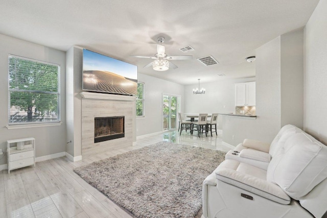 504 Chaparral Dr, Leander, TX 78641 - living room with ceiling fan, baseboards, a fireplace, a chandelier, and light wood-type flooring