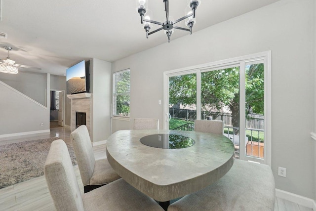 504 Chaparral Dr, Leander, TX 78641 - dining room featuring a tile fireplace, baseboards, a chandelier, and ceiling fan