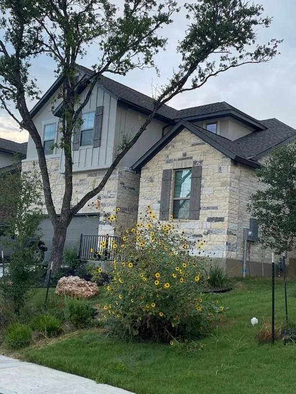 2017PALMERARIDGEBLVD, 2017 Palmera Ridge Blvd, Leander, TX 78641 - view of front of house featuring stone siding, a shingled roof, a front yard, and board and batten siding