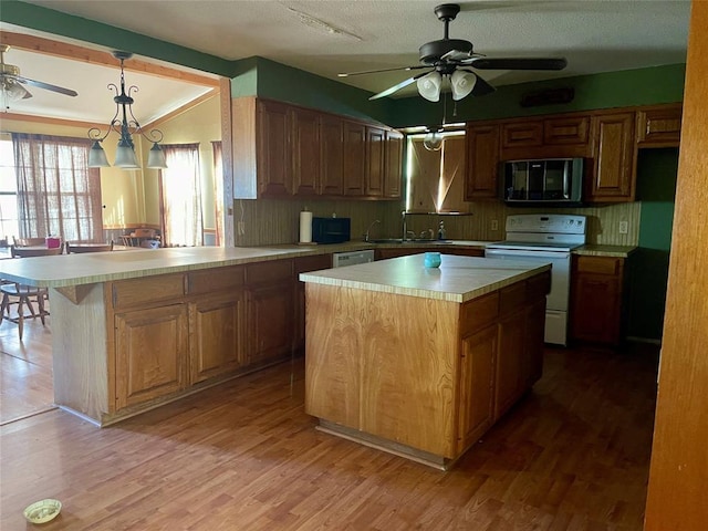 333 Spring Valley St, Hutto, TX 78634 - kitchen with black microwave, ceiling fan, white electric stove, light countertops, and light wood-style flooring