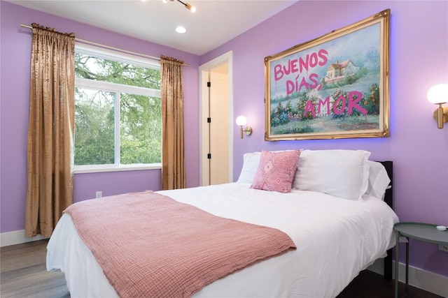 bedroom with wood finished floors, baseboards, and recessed lighting