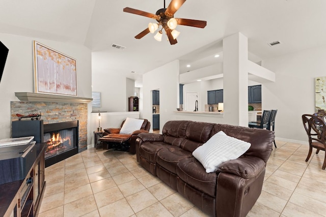 202 Dunkeld Dr, Spicewood, TX 78669 - living area with light tile patterned floors, high vaulted ceiling, a ceiling fan, a fireplace, and recessed lighting