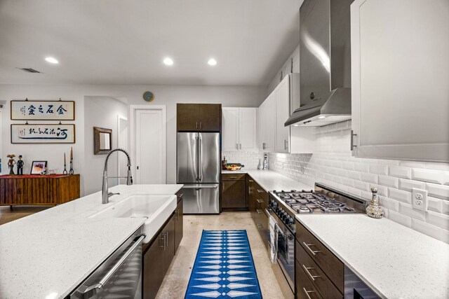 2100 E 10th St, Austin, TX 78702 - kitchen with wall chimney exhaust hood, high end appliances, a sink, decorative backsplash, and recessed lighting