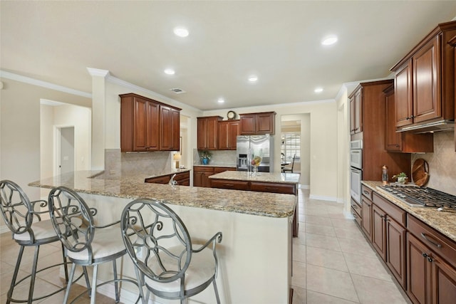 218 Duck Creek Ln, Georgetown, TX 78633 - kitchen with appliances with stainless steel finishes, a peninsula, backsplash, crown molding, and baseboards