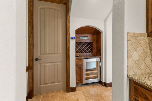 2804 Lohmans Ford Rd Unit B, Lago Vista, TX 78645 - wine room featuring wine cooler, a dry bar, arched walkways, and light stone finish floors